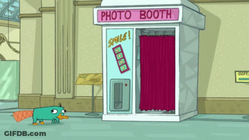 A Cartoon Of Perry The Platypus Standing In Front Of A Photo Booth In A Museum GIF