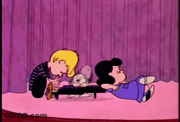 A Cartoon Of Snoopy And Lucy Playing With A Puppy GIF