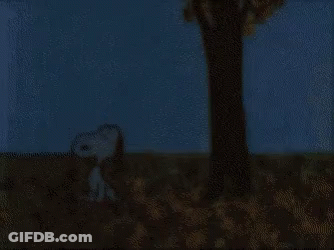 A Cartoon Of Snoopy Sitting In A Pile Of Leaves Under A Tree GIF