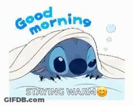 A Cartoon Of Stitch Laying Under A Blanket With The Words `` Good Morning , Staying Warm '' . GIF