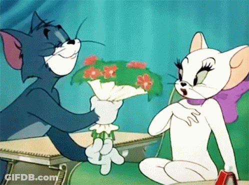 A Cartoon Of Tom And Jerry Sitting At A Desk With Tom Holding A Bouquet Of Flowers GIF