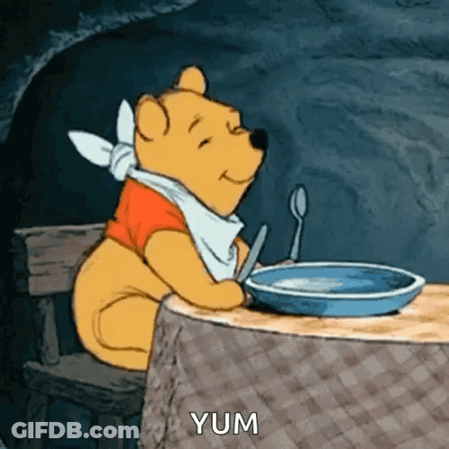 A Cartoon Of Winnie The Pooh Sitting At A Table With A Bowl Of Food And A Spoon . GIF