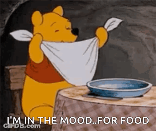 A Cartoon Of Winnie The Pooh Sitting At A Table With A Towel Around His Neck And A Bowl Of Food GIF
