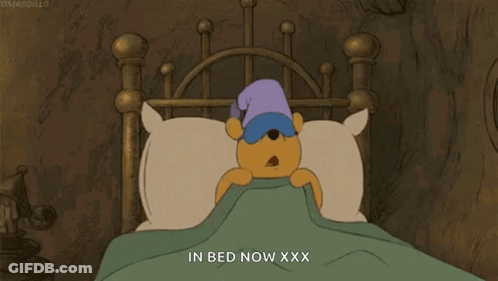 A Cartoon Of Winnie The Pooh Sleeping In A Bed GIF