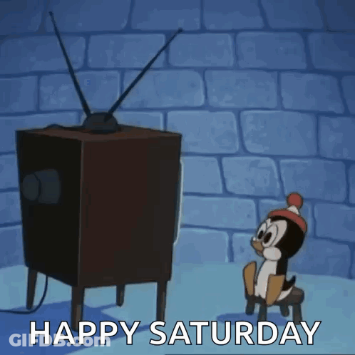 A Cartoon Penguin Is Sitting On A Stool In Front Of A Television With The Words Happy Saturday Written Below It . GIF