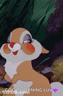 A Cartoon Rabbit Is Standing In The Woods And Smiling . GIF
