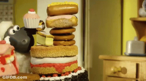 A Cartoon Sheep Is Standing Next To A Stack Of Cake And Donuts GIF