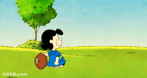 A Cartoon Shows Charlie Brown And Lucy Brown Playing With A Football GIF