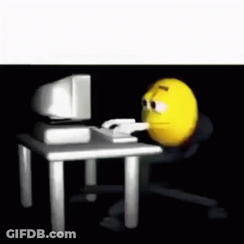 A Cartoon Smiley Face Is Sitting At A Desk In Front Of A Computer . GIF