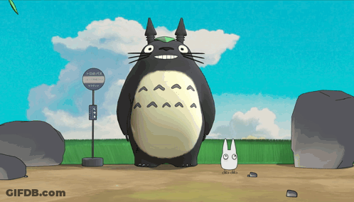 A Cartoon Totoro Is Standing Next To A Bus Stop GIF