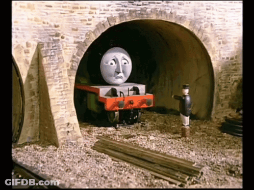 A Cartoon Train With A Sad Face Is Going Through A Tunnel GIF