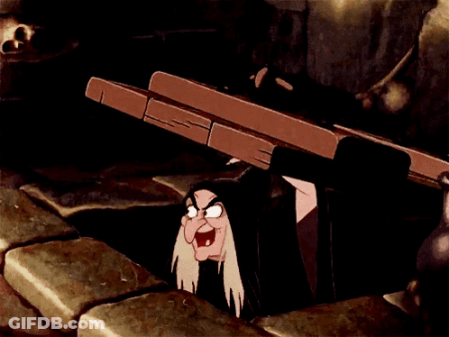 A Cartoon Witch Is Peeking Out Of A Hole In The Ground GIF