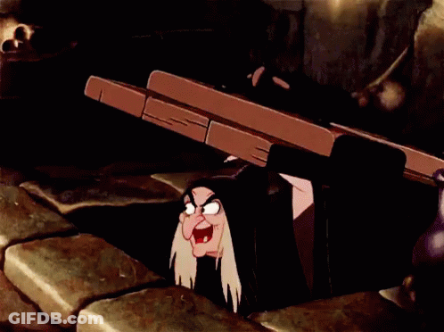 A Cartoon Witch Is Sticking Her Head Out Of A Hole In The Wall GIF