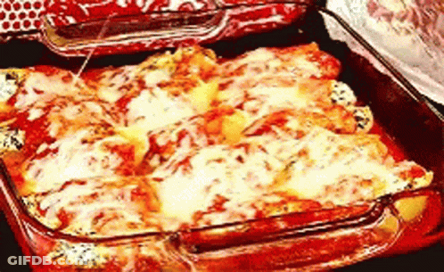 A Casserole Dish Filled With Cheese And Tomatoes GIF