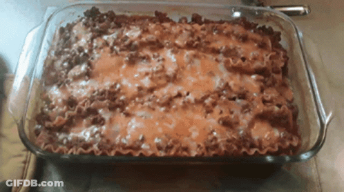 A Casserole Dish Filled With Lasagna And Cheese GIF