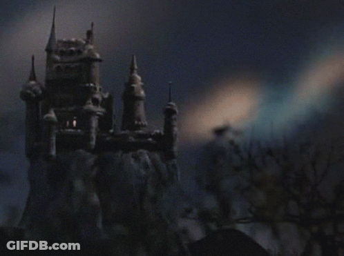A Castle On Top Of A Snow Covered Hill With Trees In The Foreground GIF