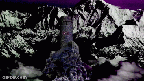A Castle On Top Of A Snow Covered Mountain With A Purple Sky In The Background GIF