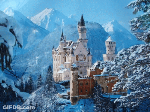 A Castle Surrounded By Snow Covered Trees And Mountains In The Background GIF