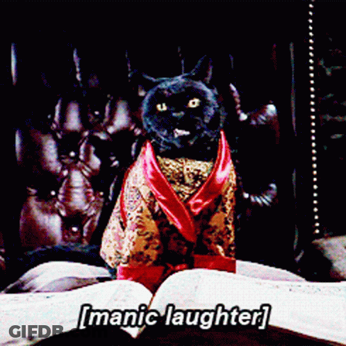 A Cat In A Robe Is Sitting On A Bed With The Words [ Manic Laughter ] Written Above It GIF