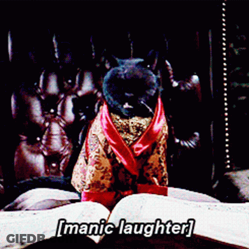 A Cat In A Robe Is Sitting On A Bed With The Words [ Manic Laughter ] Written Above It GIF
