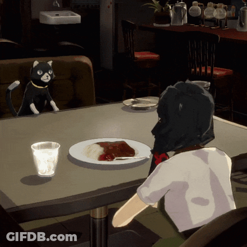 A Cat Is Sitting At A Table With A Plate Of Food GIF