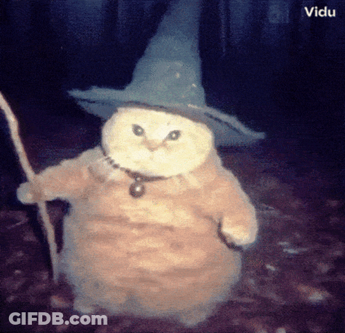 A Cat Wearing A Witch Hat And Holding A Wand GIF