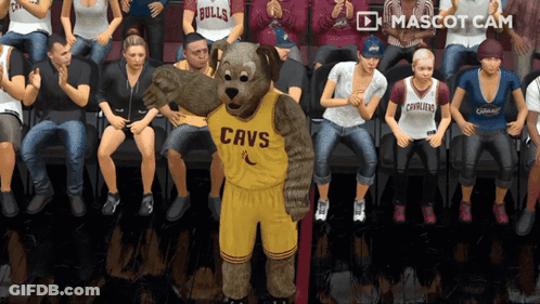 A Cavs Mascot Is Standing In Front Of A Crowd Of People GIF