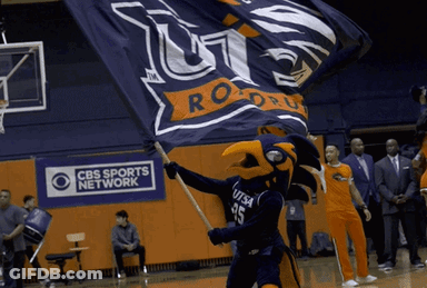 A Cbs Sports Network Ad Is Behind A Mascot Holding A Flag GIF