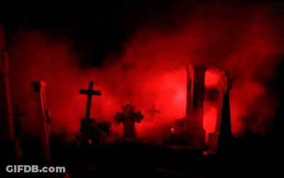 A Cemetery With Red Smoke Coming Out Of The Ground GIF