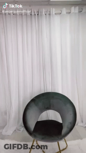 A Chair In Front Of A White Curtain With Tiktok Written On The Bottom Right GIF