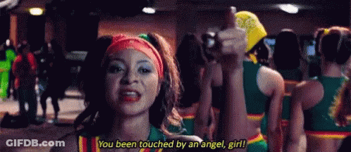 A Cheerleader Is Giving A Thumbs Up While Standing In Front Of A Crowd Of Cheerleaders . GIF