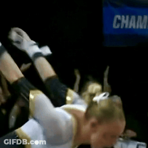 A Cheerleader Is Laying On Her Back In Front Of A Sign That Says Champ GIF