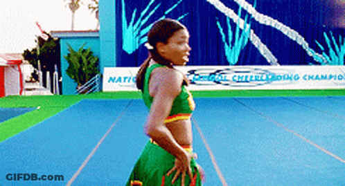 A Cheerleader Is Standing In Front Of A Sign That Says ' National Cheerleading Champion ' GIF