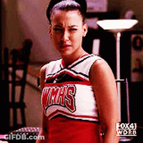 A Cheerleader Wearing A Texas Uniform Is Looking At The Camera GIF