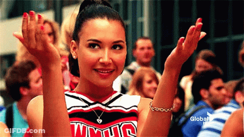 A Cheerleader Wearing A Uniform That Says Wmhs Is Clapping Her Hands . GIF
