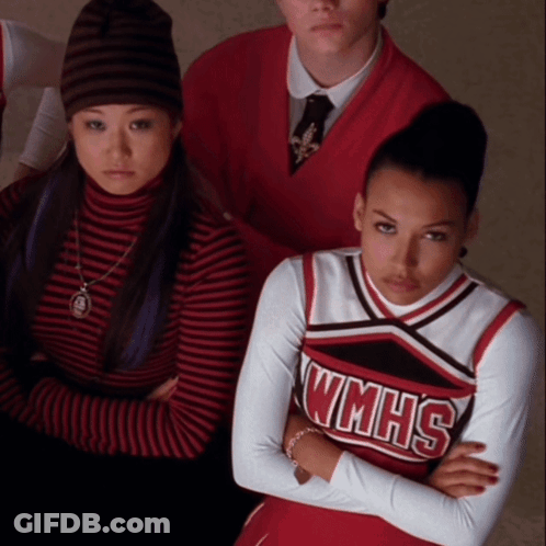 A Cheerleader Wearing A Wmhs Uniform Is Sitting With Her Arms Crossed GIF