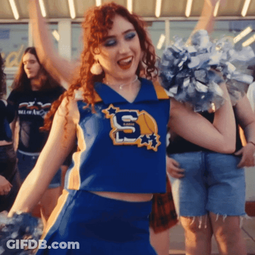 A Cheerleader Wears A Blue Uniform With The Letter S On It GIF