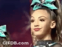Cheerleader With Blue Bow Smiling At Camera GIF