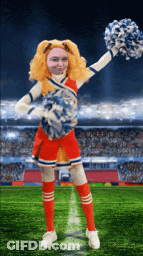 A Cheerleader With A Man 'S Face On Her Face Is Holding Pom Poms GIF