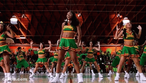 A Cheerleading Team Is Performing On A Basketball Court In Front Of A Crowd . GIF