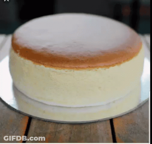 A Cheesecake Is Sitting On A Silver Plate On A Table GIF