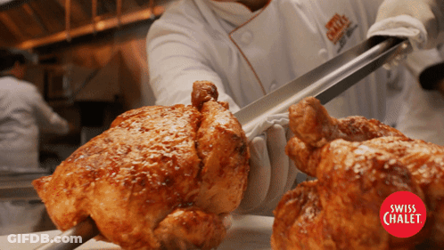 A Chef Is Cutting A Piece Of Roasted Chicken With Tongs From A Swiss Chalet Restaurant GIF