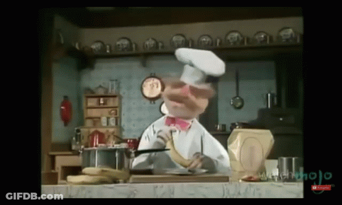 A Chef Is Holding A Banana In His Hand In A Kitchen GIF