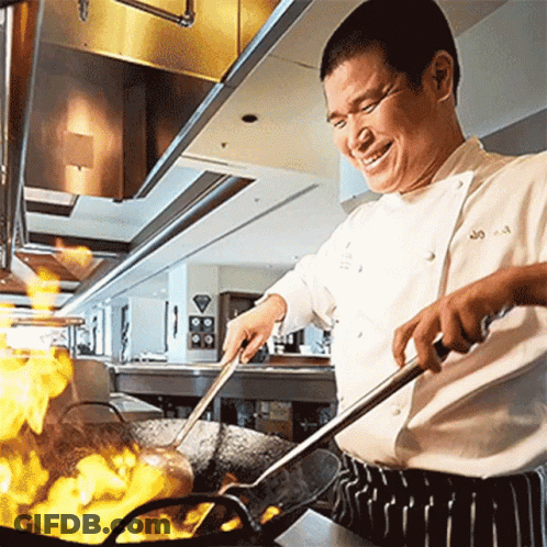 A Chef Is Smiling While Cooking In A Kitchen GIF