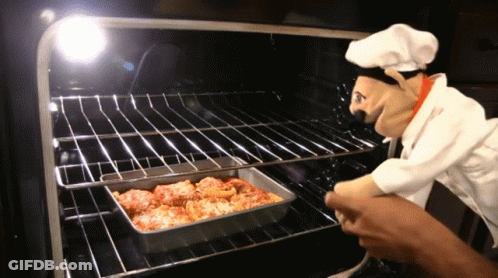 A Chef Puppet Is Looking At A Pan Of Food In The Oven GIF