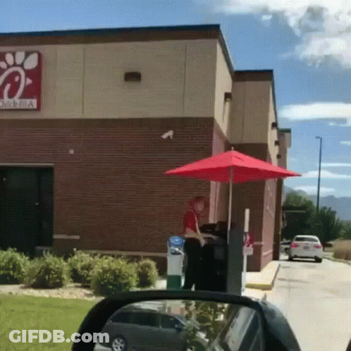 A Chick-Fil-A Drive-Thru With A Red Umbrella In Front Of It GIF