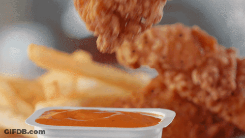 A Chicken Nugget Is Being Dipped Into A Container Of Sauce GIF