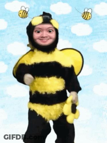 A Child Dressed In A Bee Costume With Two Bees Flying Around His Head GIF