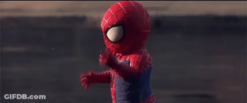 A Child Dressed In A Spiderman Costume Is Walking Down A Street GIF