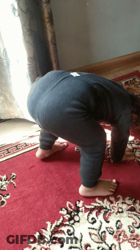 A Child Is Bending Over On A Red Rug GIF
